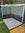 Outdoor shower area with a wooden enclosure and decorative flamingo chippings to floor.
