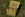 Yellow vintage-style seed box with floral design on a grassy background