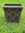 Decorative planter with decorative elements on a grassy background