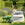 Green wheelbarrow with a bulk bag of topsoil in a cottage garden 