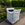 A large white bulk bag filled with compost on a wooden pallet beside a paved walkway in a landscaped garden bed with colorful flowers and green shrubs.