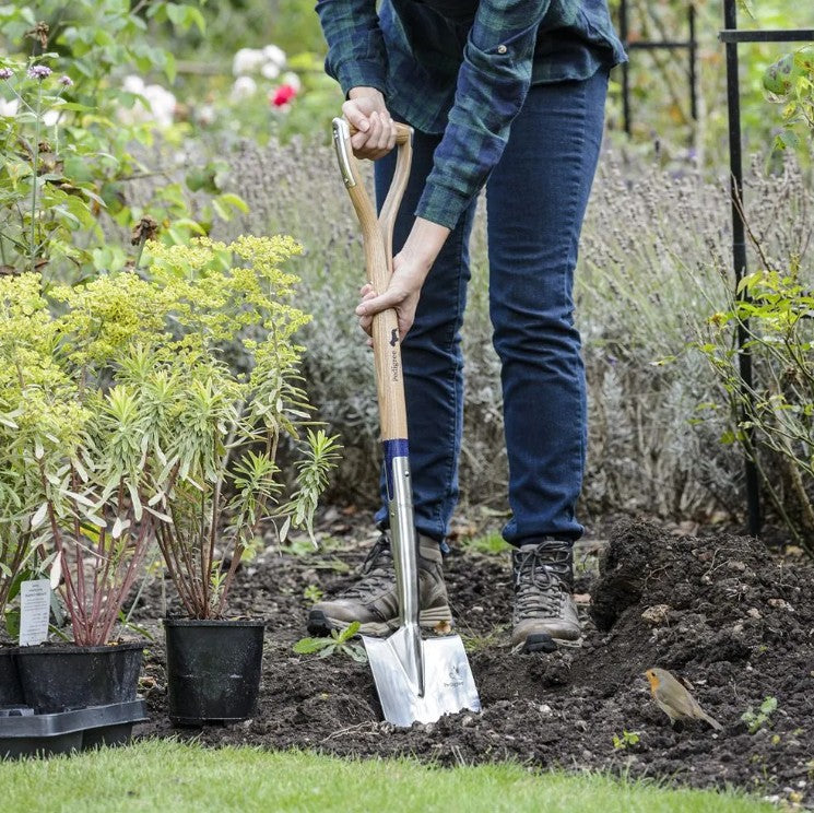 Person gardening with a Bulldog Round Point Spade in a garden setting