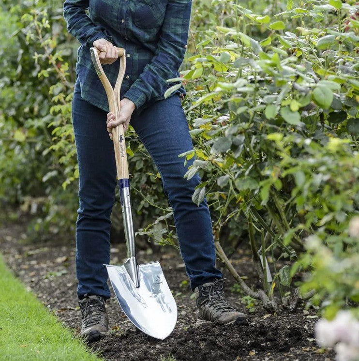 Person holding a Bulldog round point garden spade in a garden setting