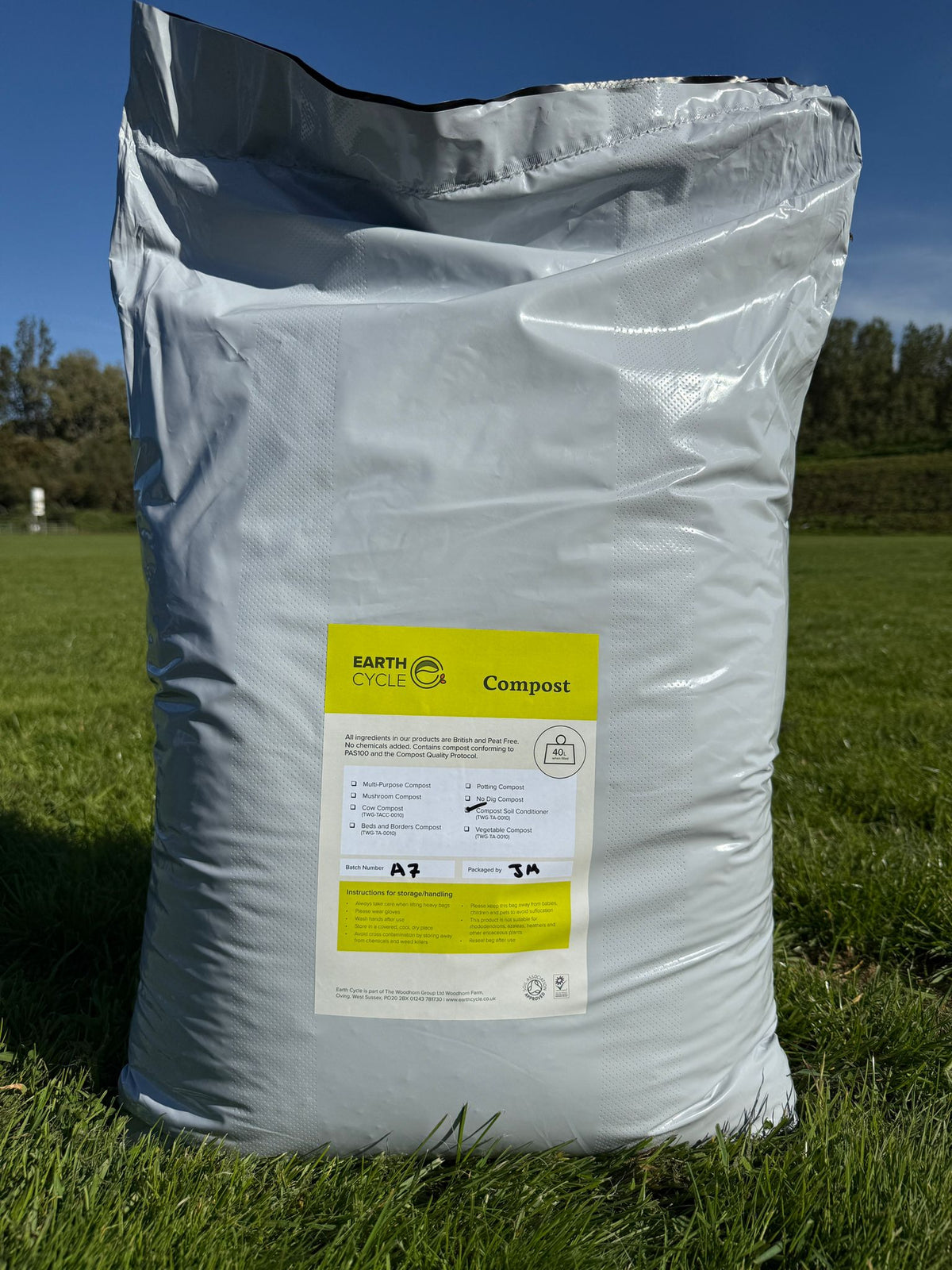 Bag of compost labeled 'Earth Cycle' on a grassy background