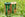 Two rolls of green and brown garden twine on grass with  packaging.