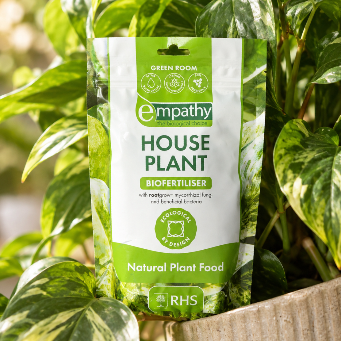 Empathy House Plant Biofertiliser among green houseplants in a planter. 